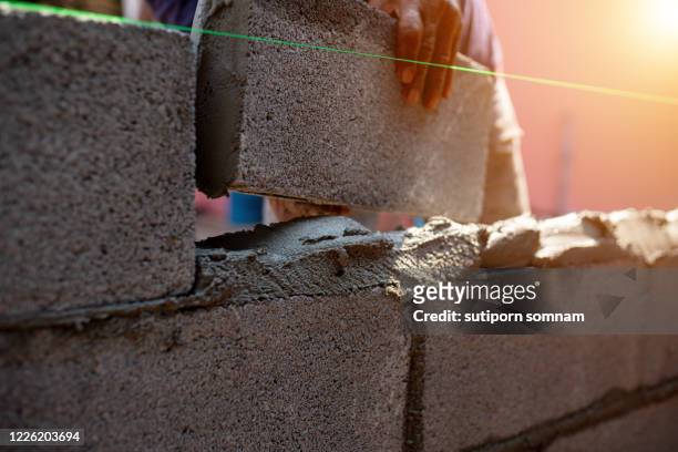 techniques for making bricks with cement for construction - brick layer stock-fotos und bilder