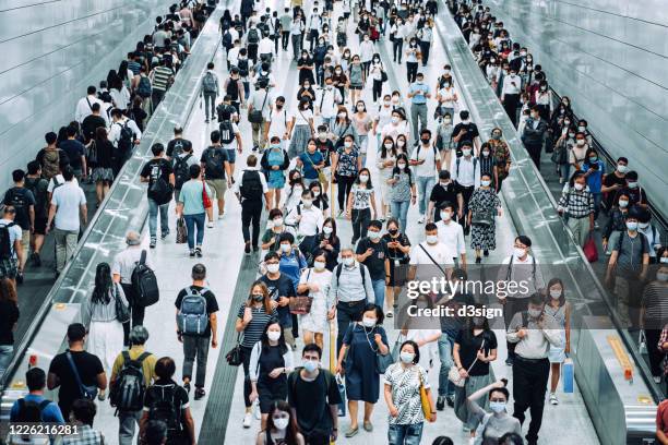 crowd of busy commuters with protective face mask walking through platforms at subway station during office peak hours in the city - china coronavirus 個照片及圖片檔