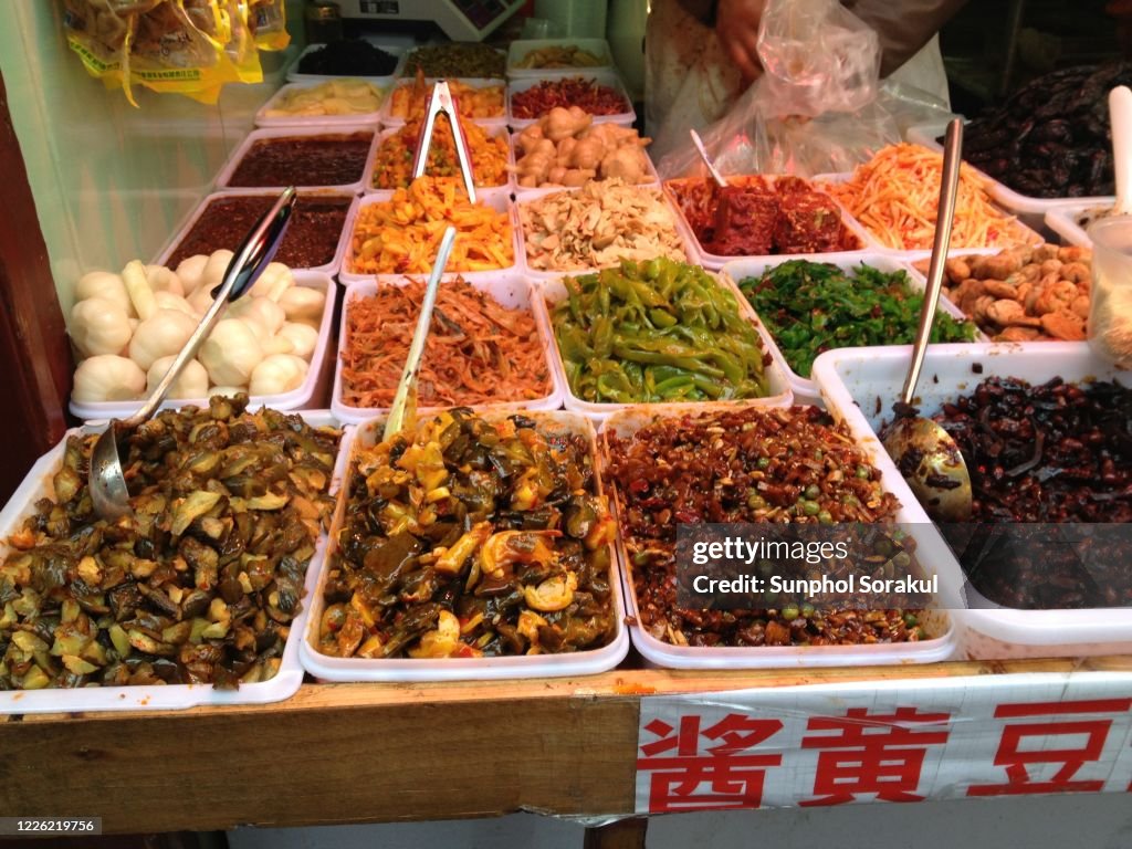 Trays of various pickled vegetables in a market street in Shanghai