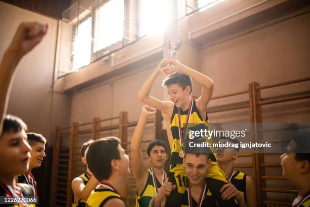 teenage basketball-team feiert sieg und trägt besten spieler auf schultern - first light awards inside stock-fotos und bilder