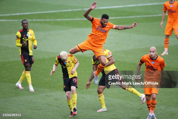 Jamaal Lascelles of Newcastle goes up and over Troy Deeney of Watford and Will Hughes of Watford during the Premier League match between Watford FC...