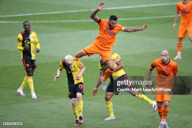 Jamaal Lascelles of Newcastle goes up and over Troy Deeney of Watford and Will Hughes of Watford during the Premier League match between Watford FC...