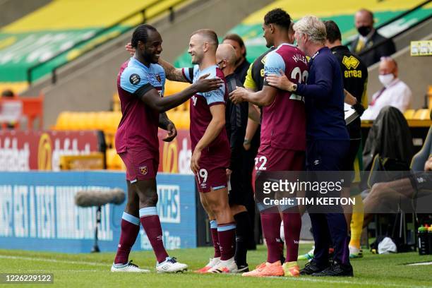 West Ham United's English midfielder Michail Antonio is congratulated by teammates and West Ham United's Scottish manager David Moyes as he leaves...