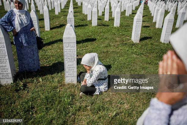 Bosnian Muslim woman cries by a grave of her father on July 11, 2020 as newly identified victims are buried at the cemetery for victims of Srebrenica...