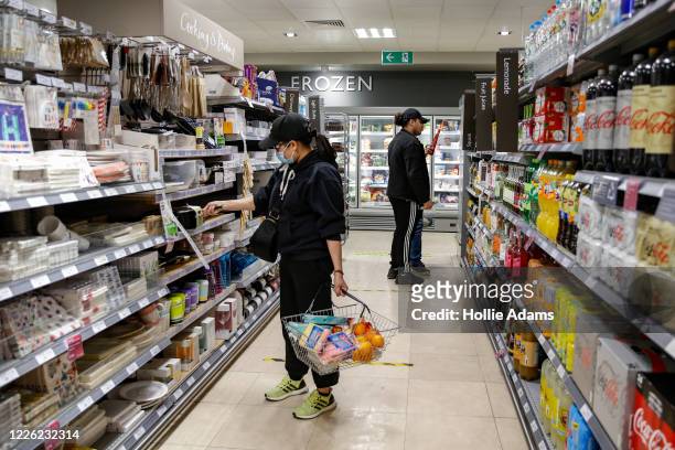 Customers wear face masks while shopping at Waitrose in Islington on July 11, 2020 in London, England. On Friday, Scotland made it mandatory to wear...