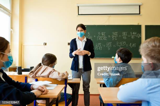 female teacher teaching mathematics at school during covid-19 - coronavirus social distancing stock pictures, royalty-free photos & images