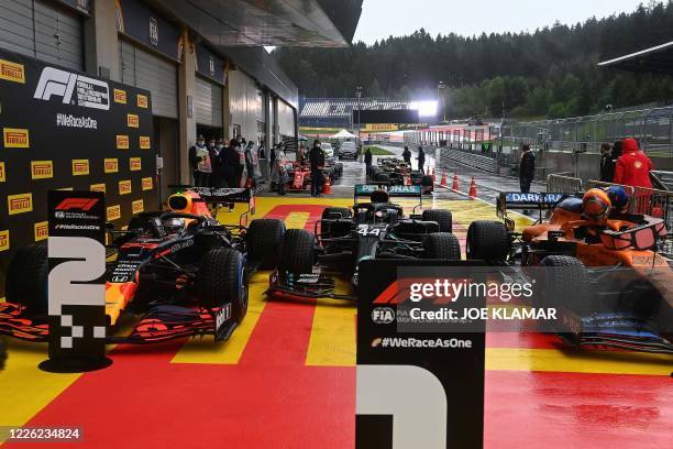 Red Bull's Dutch driver Max Verstappen, Mercedes' British driver Lewis Hamilton and McLaren's Spanish driver Carlos Sainz Jr are seen after the...