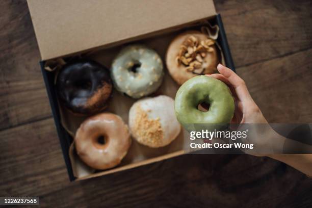 a choice of various delicious crafted donuts from a takeaway box - browsing stock pictures, royalty-free photos & images