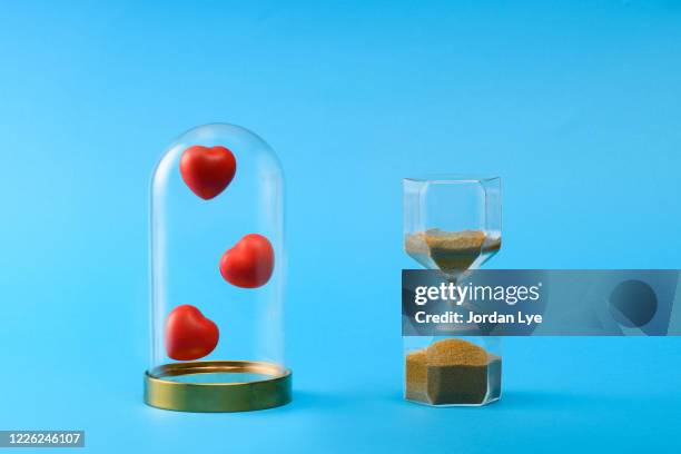 red rubber heart with sand clock - bell jar ストックフォトと画像