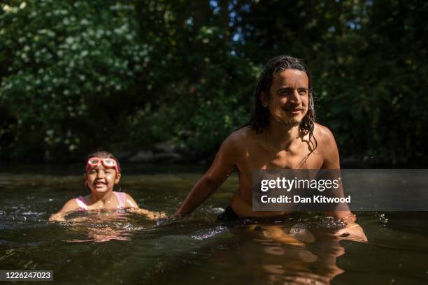 Man and his daughter cool off in the River Lea on May 21, 2020 in London, United Kingdom. This week temperatures reached 28 degrees celsius in the...