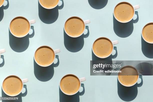 pattern made of cup of cappuccino on blue background - food pattern stock pictures, royalty-free photos & images