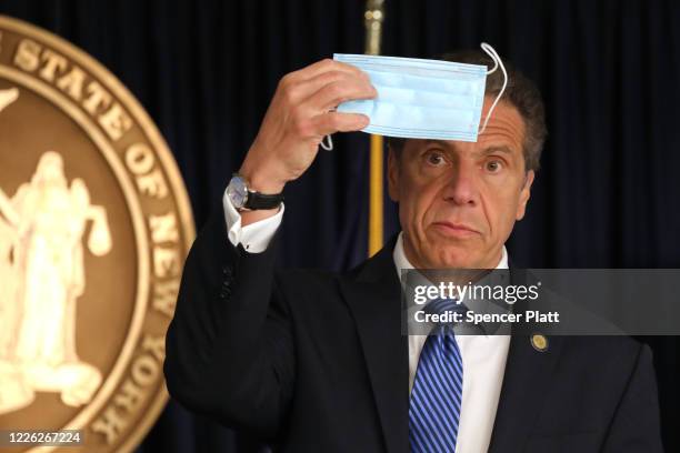 New York Governor Andrew Cuomo holds up a face mask at a news conference on May 21, 2020 in New York City. While the governor continued to say that...