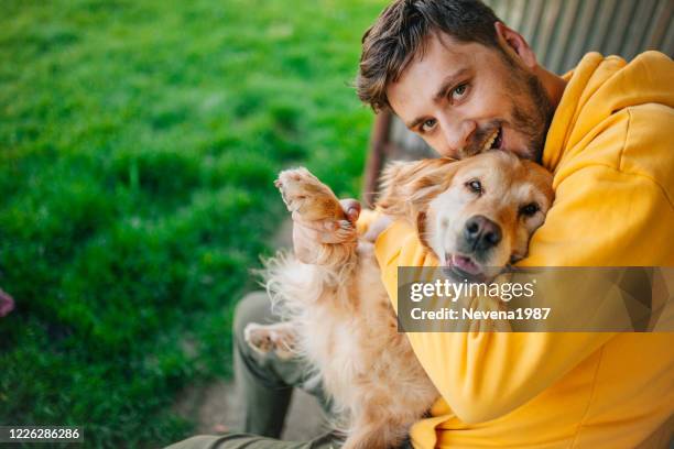 young man having a fun with his dog in the nature - friendship men yellow stock pictures, royalty-free photos & images