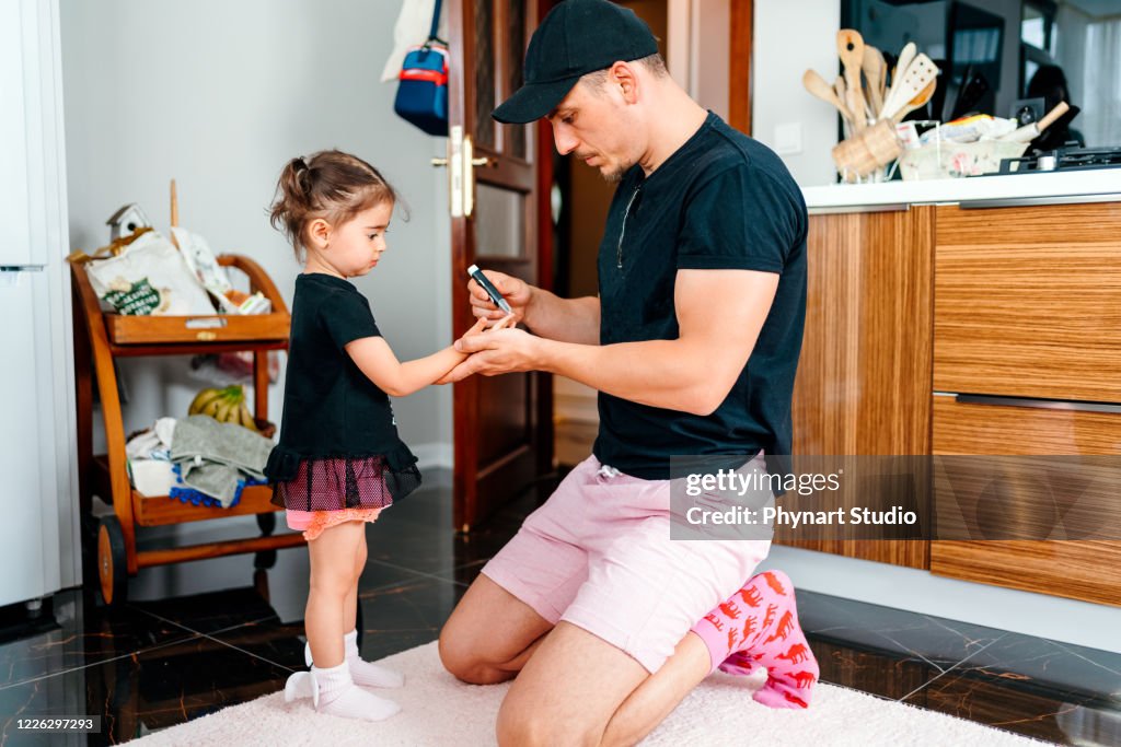 Vader controleert de bloedsuikerspiegel van dochter