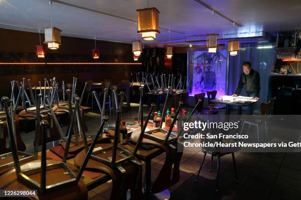 Green Papaya owner Thai Van does paperwork in his temporarily closed restaurant at the Fifth and Mission garage in San Francisco, Calif. On...