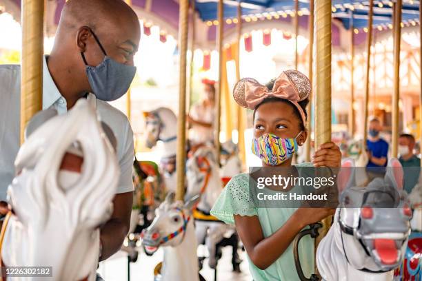 In this handout photo provided by Walt Disney World Resort, guests remain physically distanced while experiencing attractions at Walt Disney World...