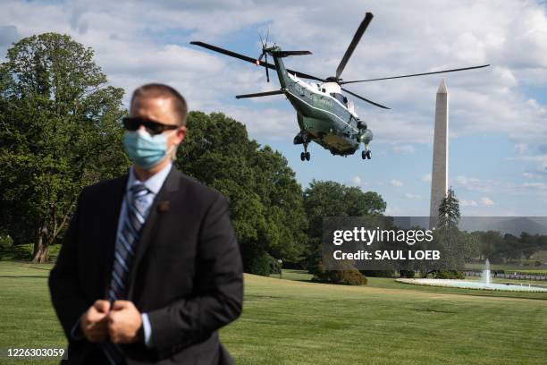 Secret Service agent stands by as Marine One, with US President Donald Trump aboard, departs from the South Lawn of the White House in Washington,...
