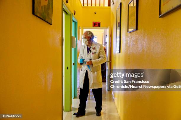 Dr. Carlos Ramirez enters an exam room to see a patient at Terra Nova Clinic in the Fruitvale neighborhood of Oakland, Calif. Tuesday, May 12, 2020....