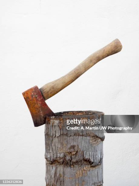 rusty axe stuck in a wooden log. - hacha pequeña fotografías e imágenes de stock