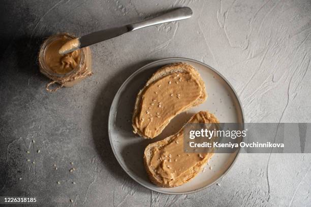 peanut butter sandwiches or toasts on light wooden background - erdnussbutter stock-fotos und bilder