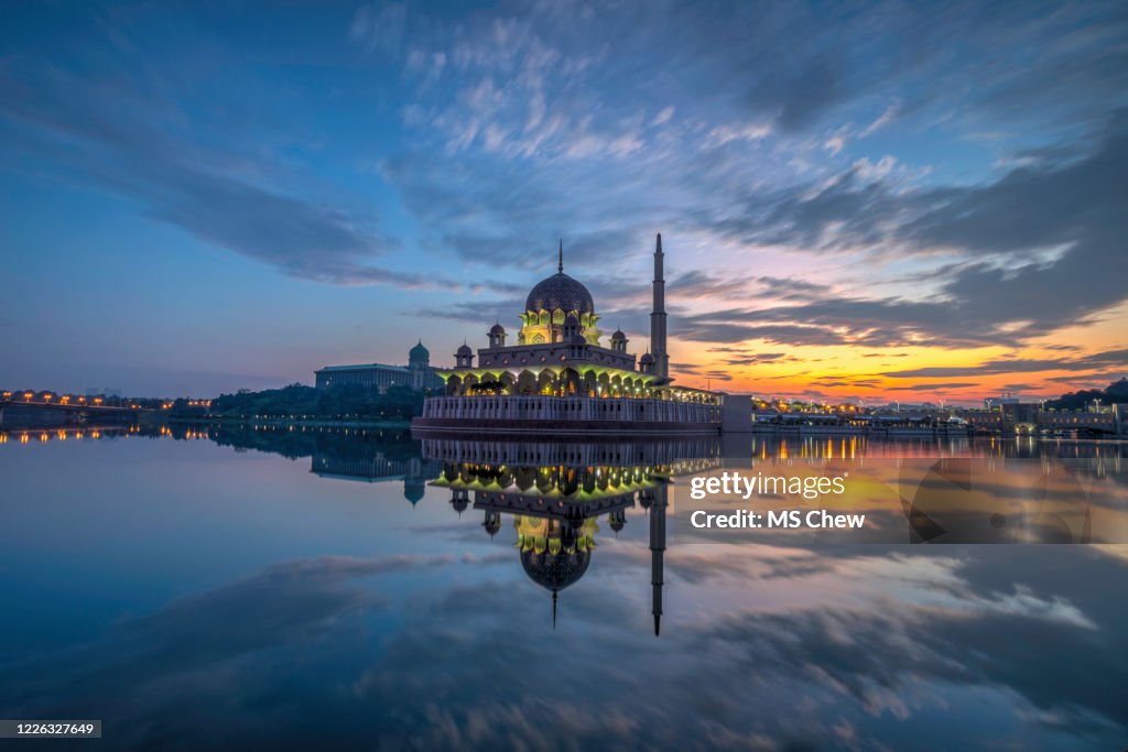 Blaue Stunde vor Sonnenaufgang mit perfekter Wasserreflexion einer Moschee