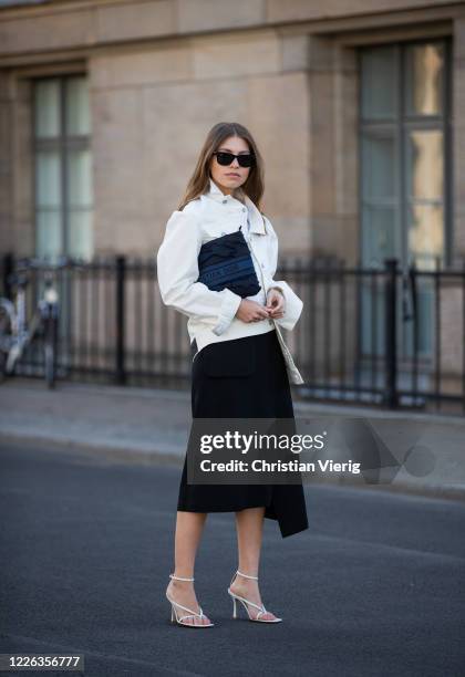 Swantje Soemmer is seen wearing white denim jacket Calvin Klein, black asymmetric skirt Aeron, white sandals Bottega Veneta, Dior clutch in navy,...