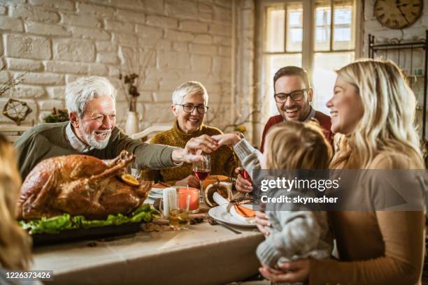 gelukkige uitgebreide familie op de maaltijd van dankzegging bij eettafel. - happy thanksgiving stockfoto's en -beelden