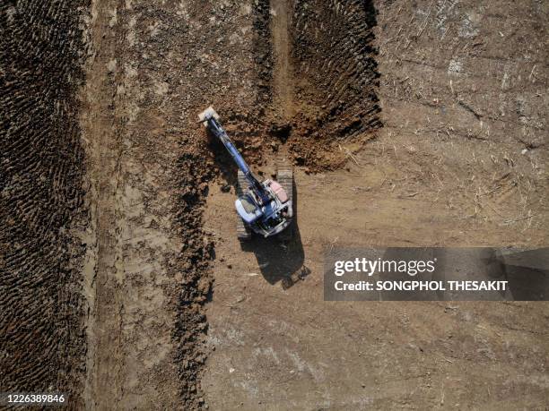 aerial view/backhoe is digging the soil for farming. - vehicle scoop stock pictures, royalty-free photos & images