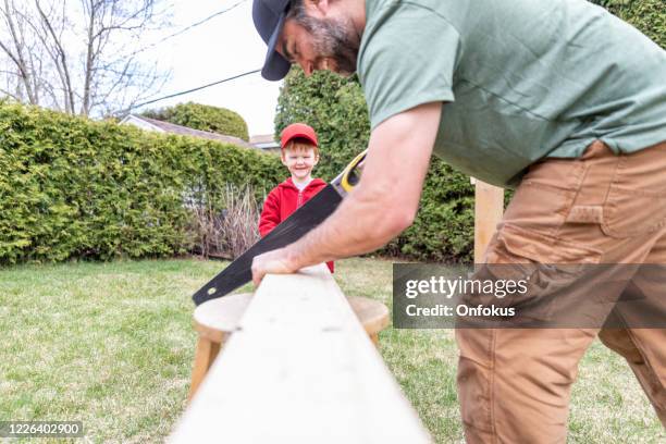 father and son doing a construction project while in quarantine - building treehouse stock pictures, royalty-free photos & images