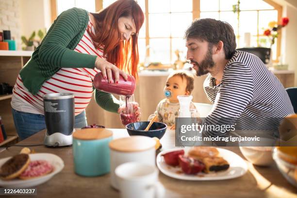 pregnant mother preparing healthy smoothie for her baby boy - baby food stock pictures, royalty-free photos & images
