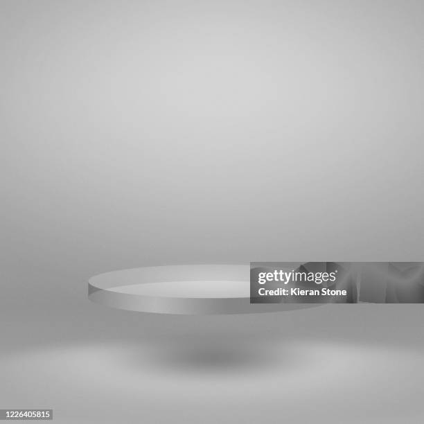 levitating glass plate in an empty studio - square plate stock-fotos und bilder