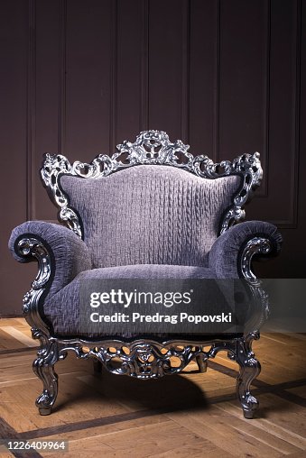 Modern luxury armchair with silver lines and violet velvet textile in dark