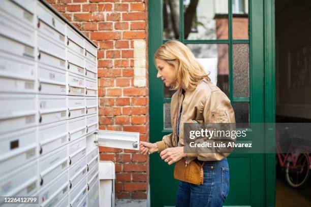 side view of active senior woman checking mailbox - letterbox stock pictures, royalty-free photos & images