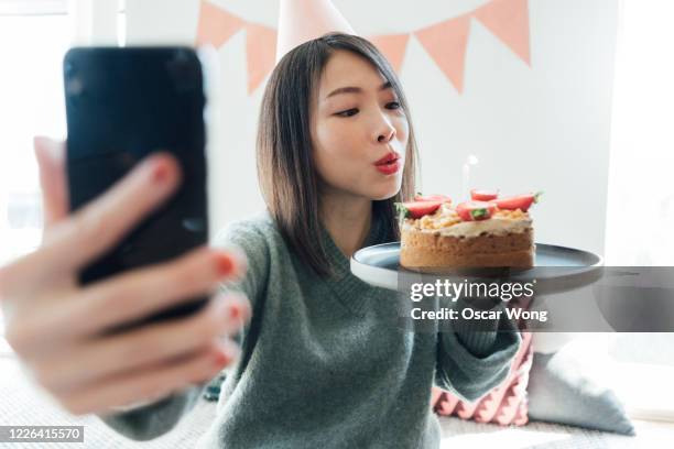 young woman having a virtual birthday party on video call with friends using smart phone - oscar party 個照片及圖片檔