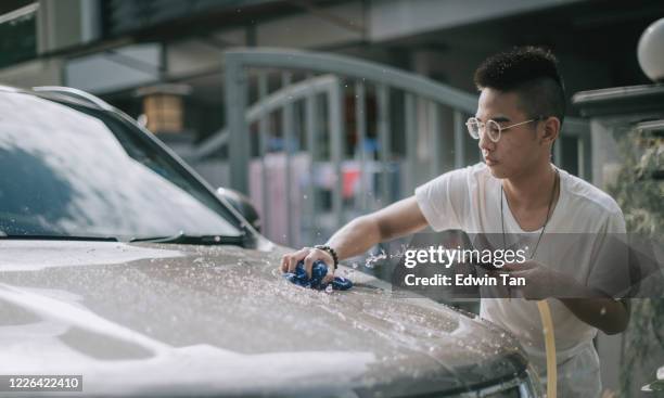 an asian chinese teenager boy washing and cleaning car in front of his house - teen wash car stock pictures, royalty-free photos & images