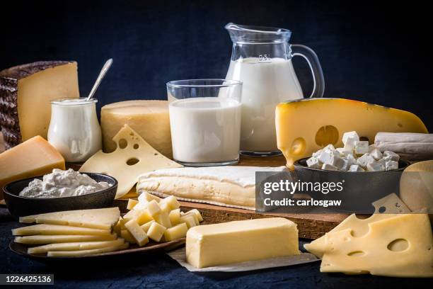 various kinds of dairy products on a dark bluish background - swiss cheese stock pictures, royalty-free photos & images