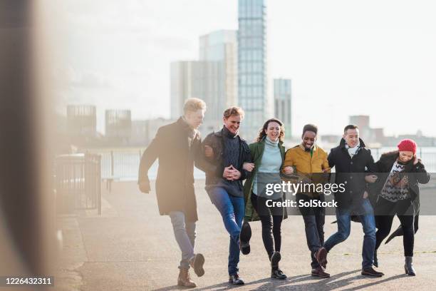 friends arm in arm - community arm in arm stock pictures, royalty-free photos & images