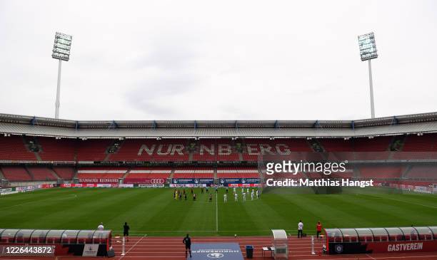 Players observe a minute's silence to commemorate the victims of the coronavirus pandemic prior to the Second Bundesliga match between 1. FC Nürnberg...