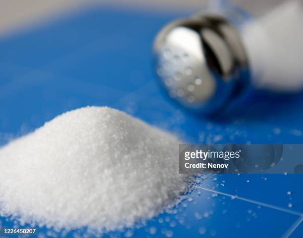 salt shaker with spilled salt on the kitchen table - pfefferstreuer stock-fotos und bilder