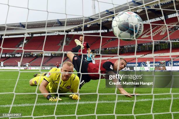 Fabian Nuernberger falls over goalkeeper Felix Dornebusch of Nuernberg as Dimitrij Nazarov of Aue scores his team's first goal during the Second...