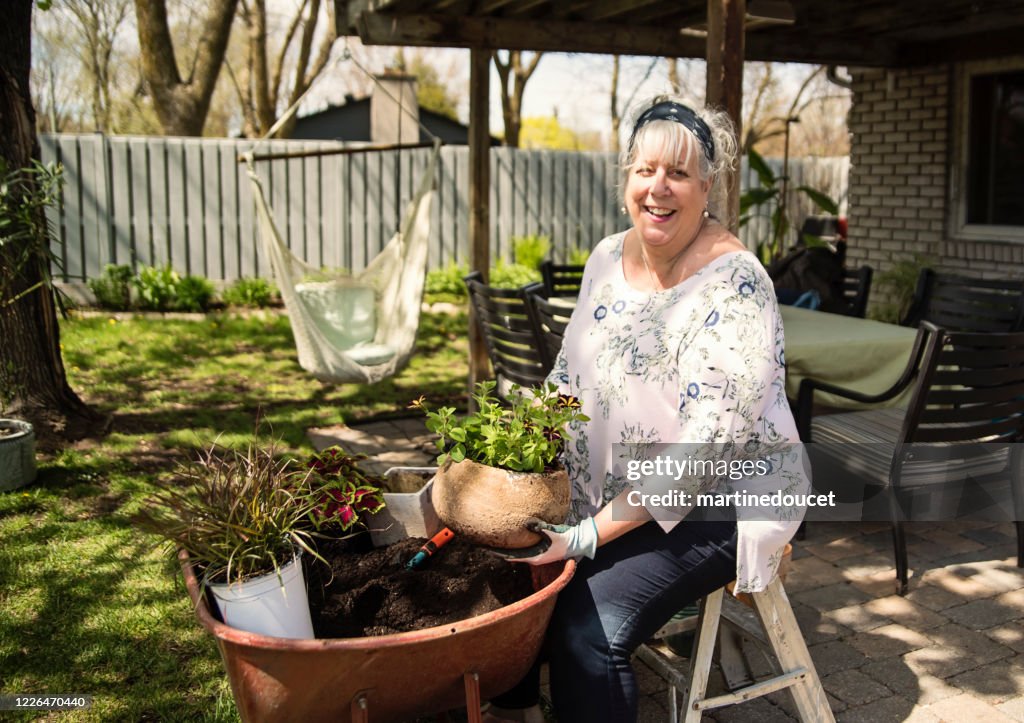 Senior woman gardening in suburban backyard.