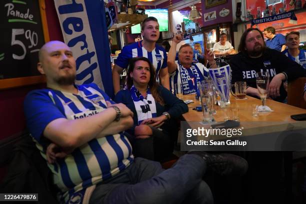 Fans of Hertha BSC football club react to their team playing against Berlin rival 1. FC Union while watching the match at live at Fraenky sports bar...