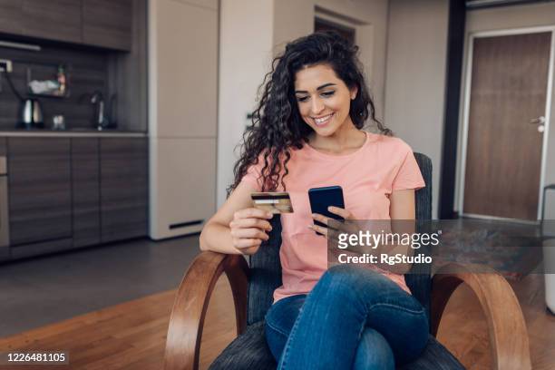 happy woman shopping online at home - credit card stock pictures, royalty-free photos & images