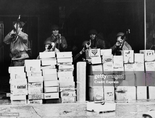 Soldiers of the National Guard shelter behind a stack of boxes during the race riots in Newark, New Jersey, in July 1967. The riots were sparked by...