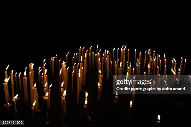 lit candles burning in the night - mourning candles stock pictures, royalty-free photos & images