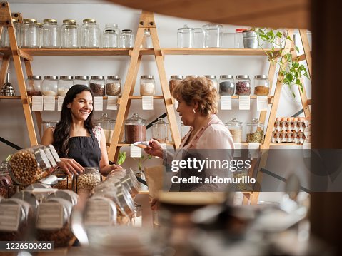Happy hispanic employee and customer smiling at each other Happy hispanic employee and customer smiling at each other