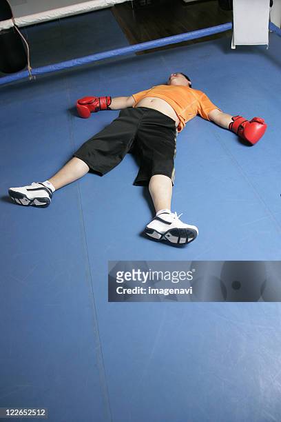 a man knocked down - fat man lying down stock pictures, royalty-free photos & images
