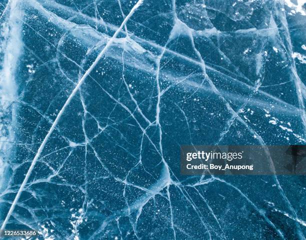 cracks surface of the frozen lake of baikal lake with frost methane bubbles in winter season. - gefrorener see stock-fotos und bilder