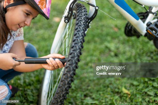 kleines mädchen reparieren ein fahrrad - luftpumpe stock-fotos und bilder