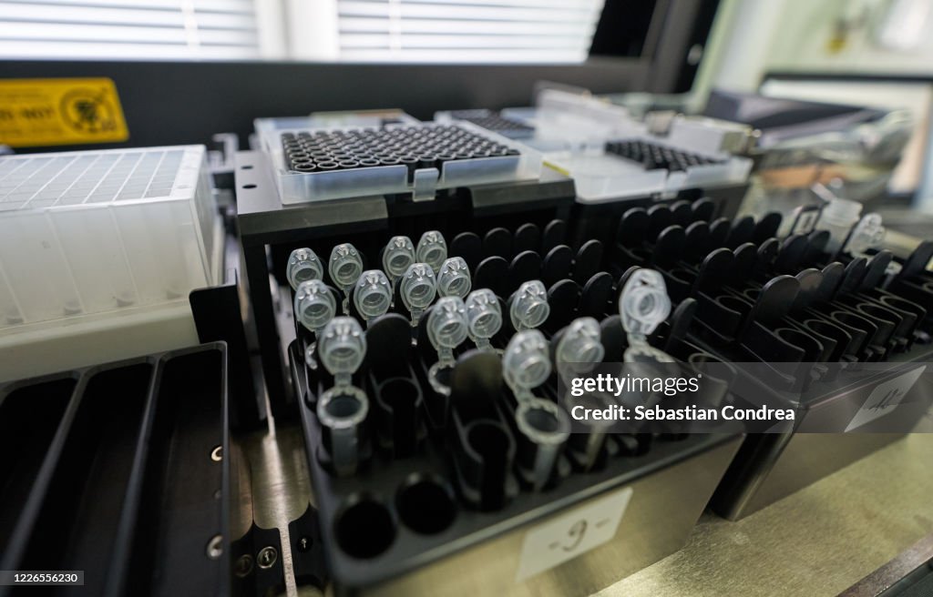 Loading a DNA tube into a PCR (polymerase chain reaction) thermocycler machine in a bioscience laboratory. Concept of science, laboratory and study of diseases